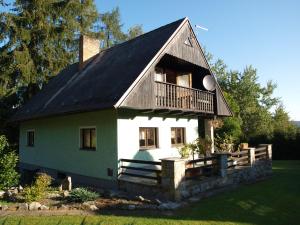 ein grünes und weißes Haus mit einem Balkon in der Unterkunft Chata Posudov - Lipno in Frymburk
