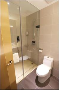 a small bathroom with a toilet and a shower at City Comfort Inn Rizhao High-speed Railway Station Yingbin Road RT-Mart in Rizhao