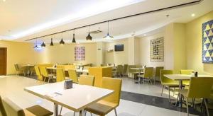 a dining room with tables and yellow chairs at City Comfort Inn Nanning Qingxiu Wanda Dongge Road Metro Station in Nanning