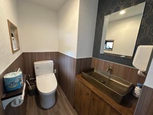Un baño con lavabo, inodoro y espejo. en とっくりhouse, en Takashima 47 fotos más