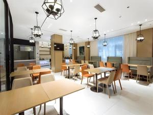 a dining room with tables and chairs at City Comfort Inn Lingshui Central Avenue Bus Station in Lingshui