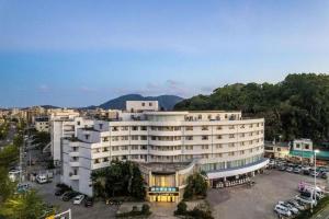 a large building with a parking lot in front of it at City Comfort Inn Lingshui Central Avenue Bus Station in Lingshui