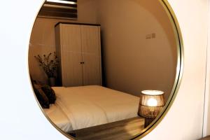 espejo que refleja un dormitorio con cama y armario en Zen Loft Getaway, en Is-Swieqi