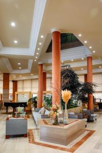 a lobby with couches and a grand piano at Gran Hotel de Ferrol in Ferrol