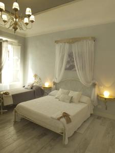 a bedroom with two beds and a chandelier at Antica Loggetta in Ravenna