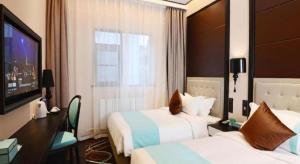 Xana Hotelle Xi'an Zhonglou, Huimin Street Metro Station في شيان: غرفة فندقية بسريرين وتلفزيون