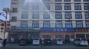a large building with cars parked in front of it at City Comfort Inn Lhasa Gongga County Gongga Airport in Zamsar