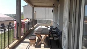 a balcony with a wooden table and chairs on a building at Dama Apartment in Senj