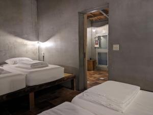 a room with two beds in a room with a hallway at 都蘭小星民宿 Dulan Star Guest House in Donghe