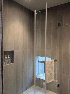 una ducha con puerta de cristal en un baño en 都蘭小星民宿 Dulan Star Guest House, en Donghe