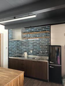 una cocina con fregadero y refrigerador en とっくりhouse, en Takashima