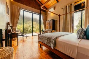 a bedroom with a large bed and large windows at Rosewood Manor in Botiyatenna