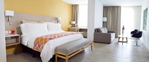 a hotel room with a bed and a desk at Mercure Santa Marta Emile in Santa Marta