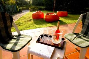 uma mesa com uma garrafa de vinho e duas cadeiras em Casa da Miza em Vilar do Pinheiro