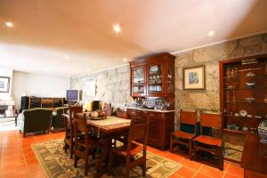 Un comedor con una mesa y una pared de piedra. en Casa da Miza, en Vilar do Pinheiro