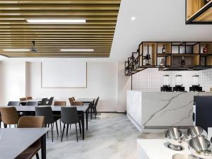 a restaurant with tables and chairs in a room at GEM Hotel Changzhou Xuejia'aoyuan North High-Speed Railway Station in Changzhou