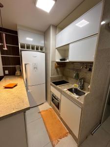 Una cocina con un refrigerador blanco y un fregadero. en Jubiabá - 1110 A - Net 200 MB, en Olivença