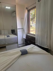 Un dormitorio con una cama y un espejo grande. en Jubiabá - 1110 A - Net 200 MB, en Olivença