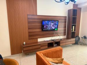 un soggiorno con una TV a schermo piatto su una parete di Appartement chic et moderne wifi Starlink a Douala