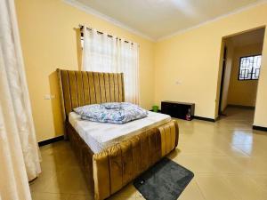 een slaapkamer met een bed in een kamer met gele muren bij CnRAirBnB in Iringa