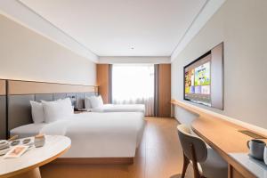 Ένα ή περισσότερα κρεβάτια σε δωμάτιο στο JI Hotel Shenzhen Bao'an International Airport Huaide