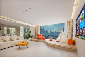 a living room with a couch and a tv at Yangshuo Yundu Panoramic Luxury Hotel in Xingping