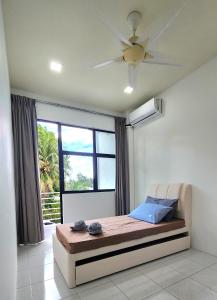 CC Regalia Homestay Kota Samarahan Kuching Sarawak في Kota Samarahan: غرفة نوم مع سرير مع مروحة سقف ونافذة +44 صورة