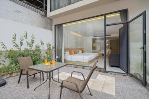 a patio with a table and chairs and a bed at Yangshuo Yundu Panoramic Luxury Hotel in Xingping