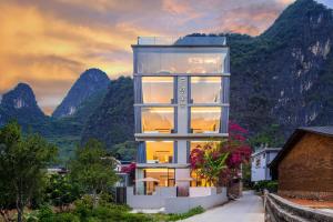 a glass house with mountains in the background at Yangshuo Yundu Panoramic Luxury Hotel in Xingping