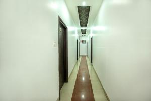 un lungo corridoio con due porte e una panca di Hotel O by OYO MM Yellowuds ad Amritsar
