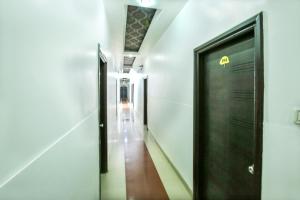 un corridoio con una porta nera in un edificio di Hotel O by OYO MM Yellowuds ad Amritsar