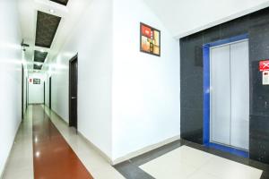 un corridoio di un edificio con pareti bianche e una porta di Hotel O by OYO MM Yellowuds ad Amritsar