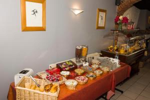 einen Tisch mit Körben mit Lebensmitteln darüber in der Unterkunft LOGIS Hôtel - Les Paturelles in Avesnelles