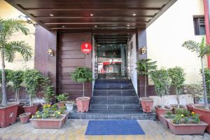 una porta d'ingresso di un edificio con scale e piante di Hotel O by OYO MM Yellowuds ad Amritsar Altre 17 foto