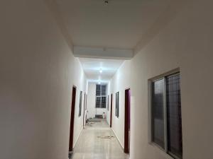 a hallway with white walls and pictures on the walls at Hotel O Green Villa in Bilāspur +4 photos