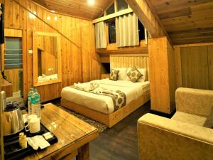 a bedroom with a bed and a table in a room at Retreat Hotel Queen in Darjeeling