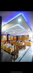 a restaurant with tables and chairs and purple lighting at Retreat Hotel Queen in Darjeeling