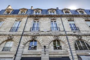 ein Steingebäude mit Fenstern und einem Dach in der Unterkunft Appartements Place Gambetta - YBH in Bordeaux