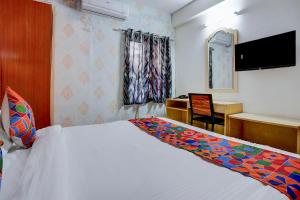 a bedroom with a bed and a desk with a computer at FabHotel Tap Inn in Bengaluru +22 photos