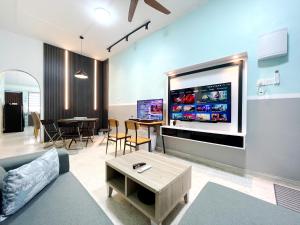 #SP Cozy&Warm 3Bedroom HomeStay 10PAX by S&T Homez في سِريمبان: غرفة معيشة مع تلفزيون بشاشة مسطحة كبيرة على الحائط