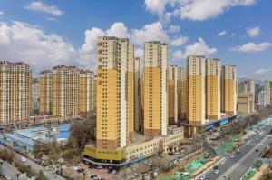 a city with tall yellow buildings and a street at Vienna Hotel Qinghai Xining Wanda Plaza in Xining