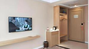 a living room with a flat screen tv on a wall at Vienna Hotel Shandong Qingdao Taidong Pijiu Street Liaoning Road in Qingdao