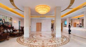 a lobby with a large room with a large rug at Vienna Hotel Hubei Jinzhou Changjiang University in Caoshi