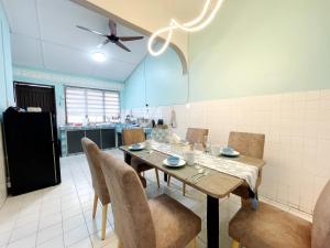 #SP Cozy&Warm 3Bedroom HomeStay 10PAX by S&T Homez في سِريمبان: غرفة طعام مع طاولة وكراسي في مطبخ +27 صورة
