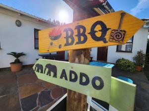 a wooden sign on a pole in front of a house at Alcyone in Gqeberha