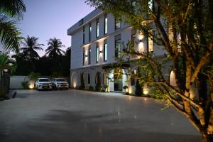 a building with two cars parked in a parking lot at RS1 Hotel in Ban Pho Touane