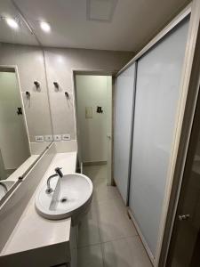 Un baño con lavabo blanco y ducha en Jubiabá - 1110 A - Net 200 MB, en Olivença 16 fotos más