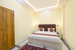 a bedroom with a bed and a wooden door at FabHotel Rubicon in Faridabad