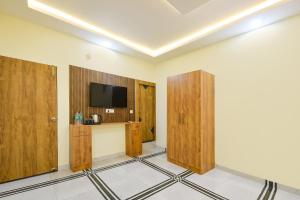 a room with wooden doors and a tv on the wall at FabHotel Rubicon in Faridabad
