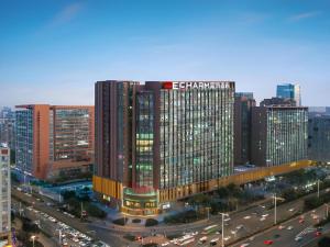 a large building in a city with traffic at Echarm Hotel Nanjing Expo Center Olympic East Metro Station in Nanjing
